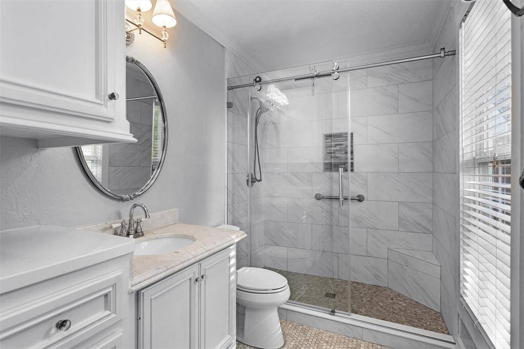 Generous cabinet space, hex tile flooring and massive walk-in shower with frameless shower doors accentuate the ensuite.