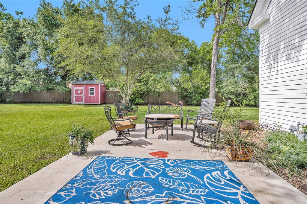 A side concrete patio is perfect for a firepit. Also included is the red storage building.