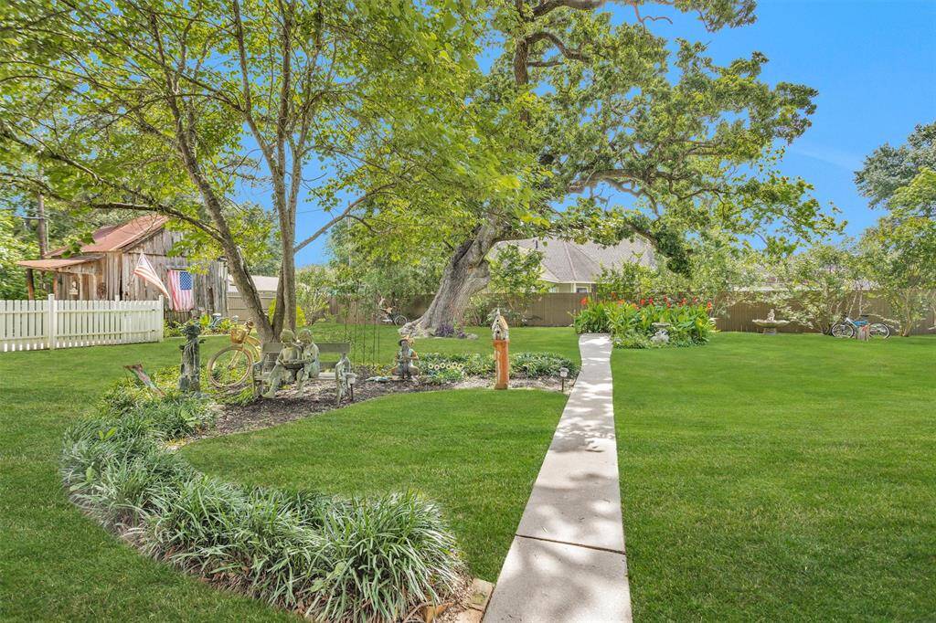 The meticulously maintained yard with a pathway leading to the garden.