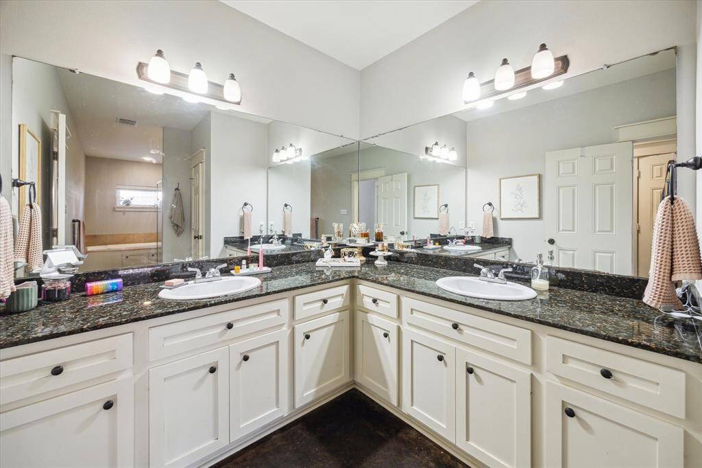 Elegant first-floor primary bathroom with dual sinks and granite countertops.