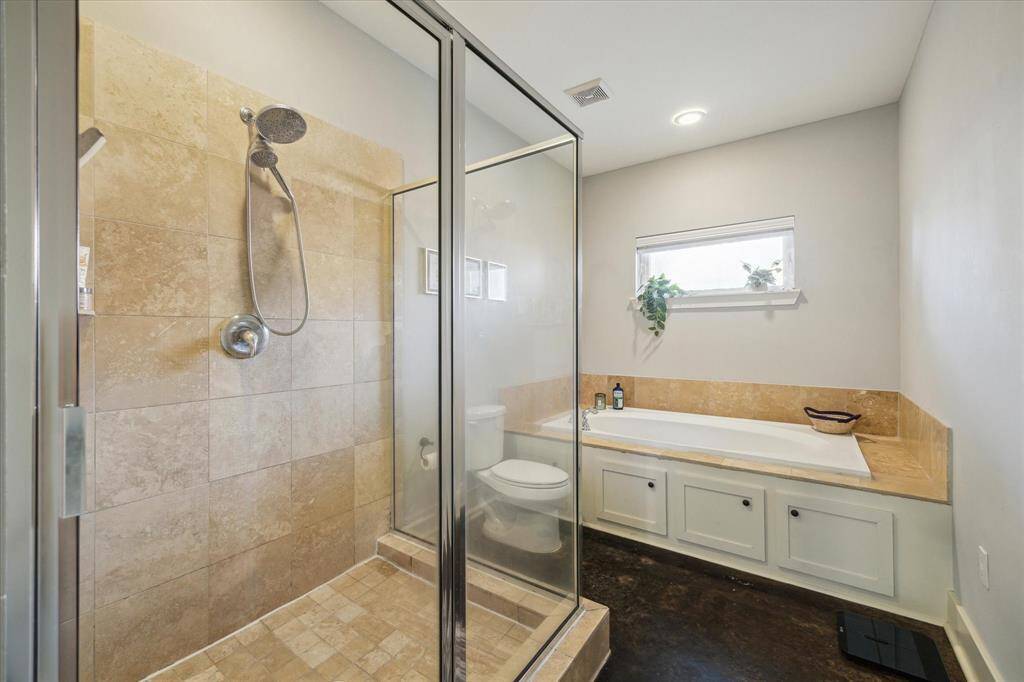 Luxurious first-floor primary bathroom featuring a separate shower and a spacious soaking tub.