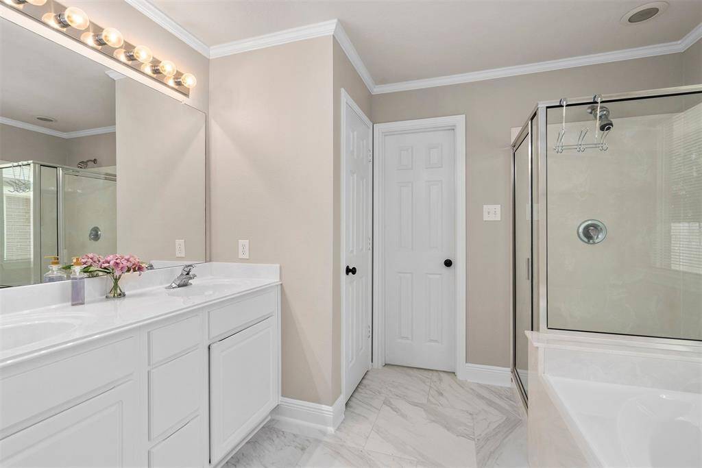 Master bath with double sinks, new tile flooring, new toilet, separate shower and tub!
