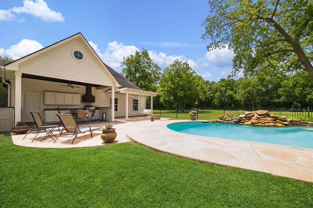 The summer kitchen is equipped with a grill, sink, granite counters and an instant hot water heater under the cabinet. On the ceiling in the kitchen and the pergola are fans to keep you cool while cooking or swinging.