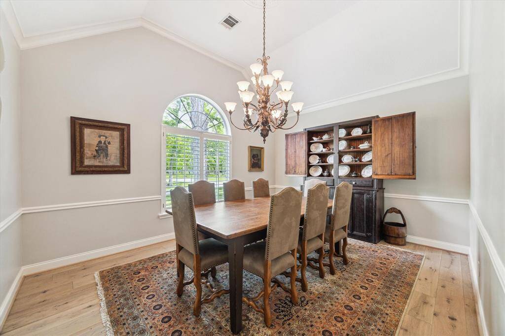 This view of the formal dining room highlights the white oak flooring that runs through the main living space. The baseboards are seven inches in height. Prominent window coverings in the home are Plantation Shutters.