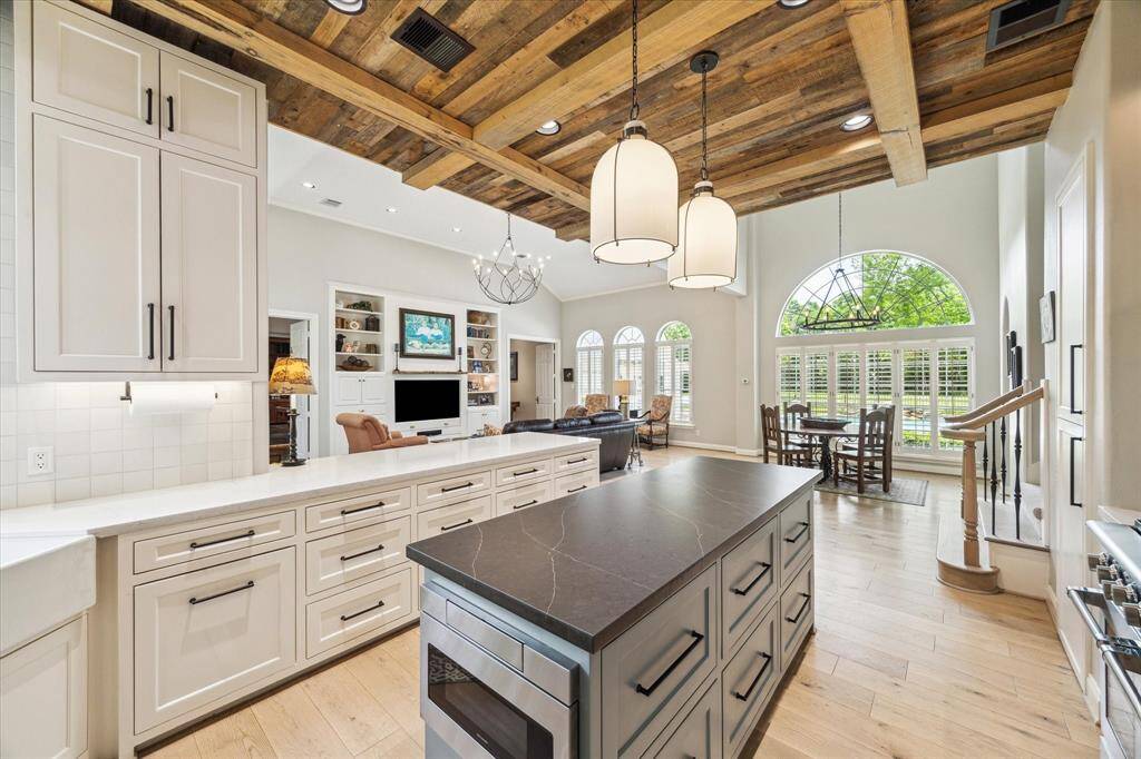 The kitchen is a show stopper and was completely restructured during the renovation. The ceiling is dressed with antique barn wood siding and beams. It is open to the less formal breakfast area and family room.