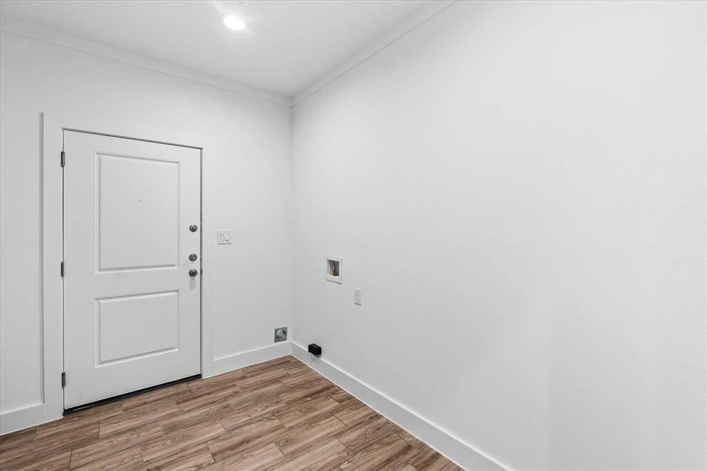 Laundry room with door that leads to the side.
