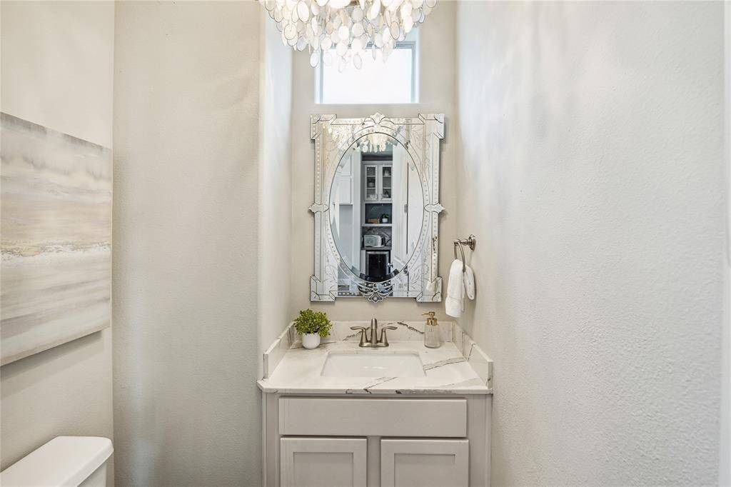 POWDER.  A sprinkle of glamour in this powder room tucked away off the kitchen with custom lighting and mirror.