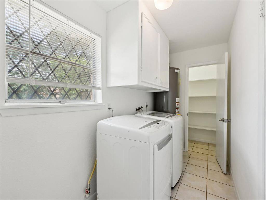 The generous Utility room has a washer and dryer that conveys with the home. The walk-in pantry is in the background.