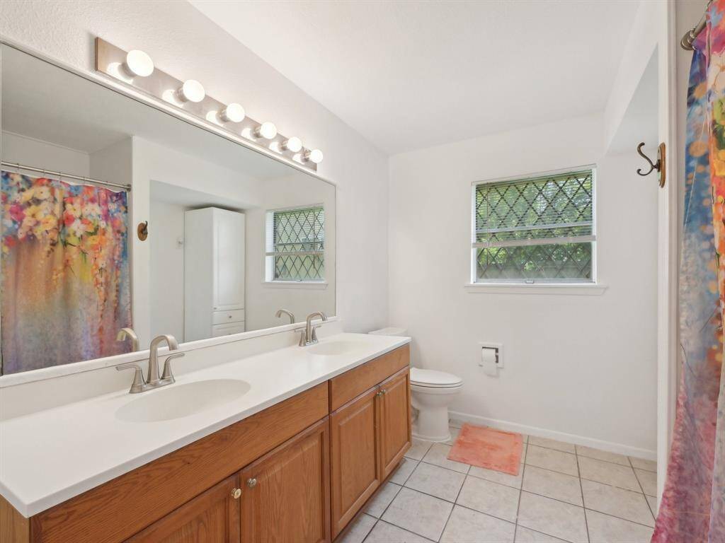 The downstairs bathroom has double sinks and tiled flooring.