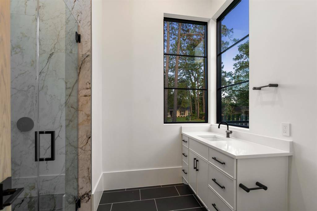 The main floor suite’s private bathroom enjoys corner windows, a crisp white vanity and a walk-in shower.