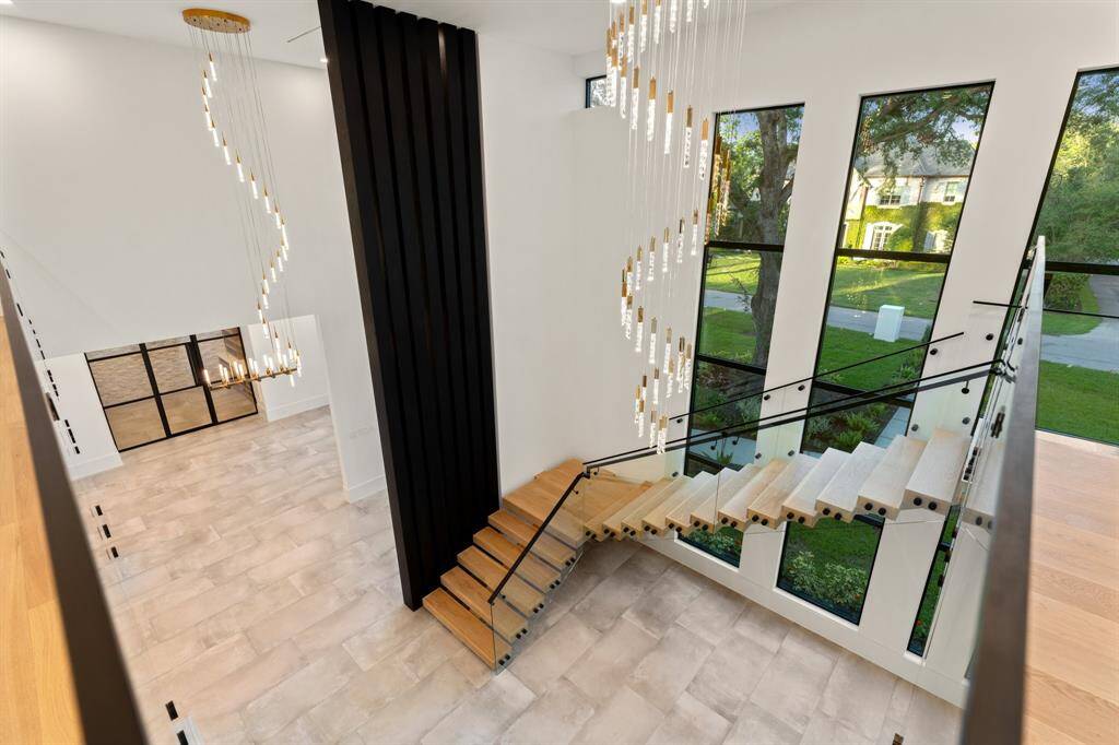 Glass handrails along the open staircase and mezzanine allow sunlight and views to flow unimpeded throughout this exquisite home.