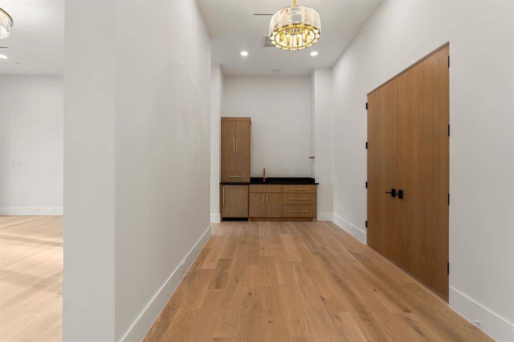 Double doors and a large vestibule introduce the palatial owner’s suite on the upper level. Here, a coffee bar with a sink and refrigerator makes it easy to greet each day.