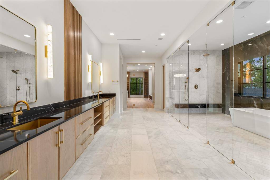 The massive, magazine-worthy primary bathroom takes your breath away with its exquisite hardware and floor-to-ceiling granite and marble tile. Enjoy an extra-wide double vanity, two private water closets with Toto commodes, and a windowed wet room.