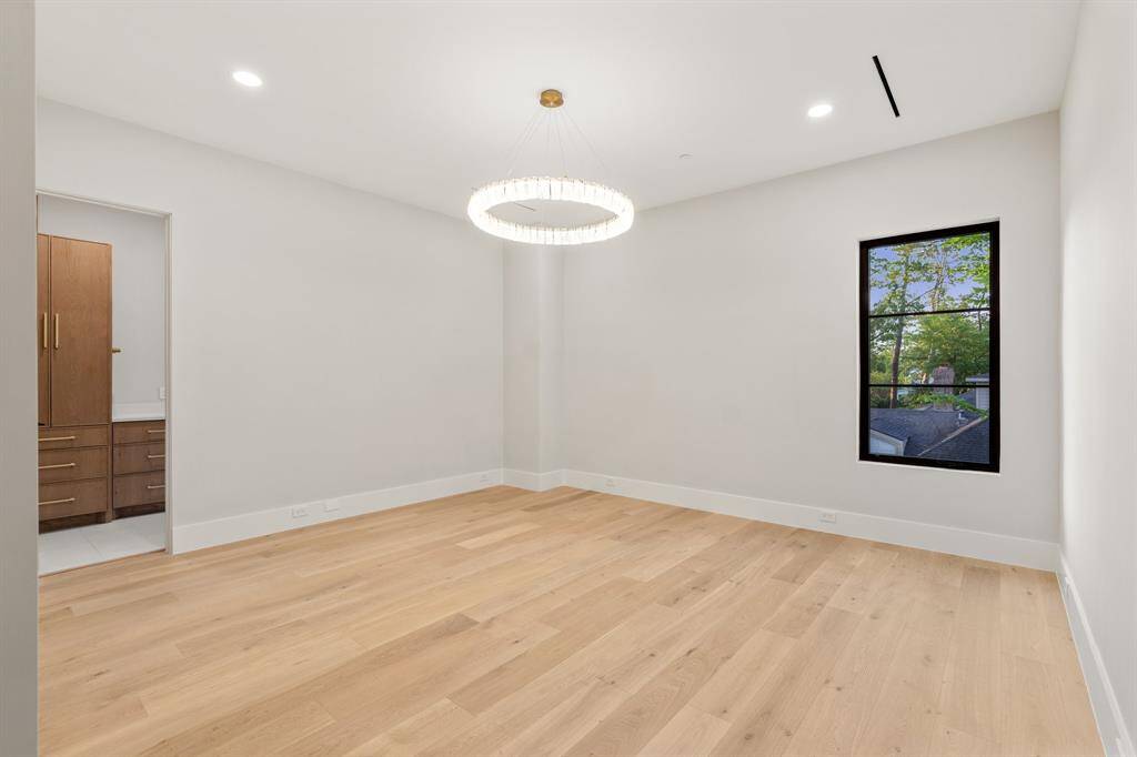 This 18-foot by 16-foot secondary suite features a northern window, a beautiful wheel chandelier, a private bath and a custom walk-in closet.