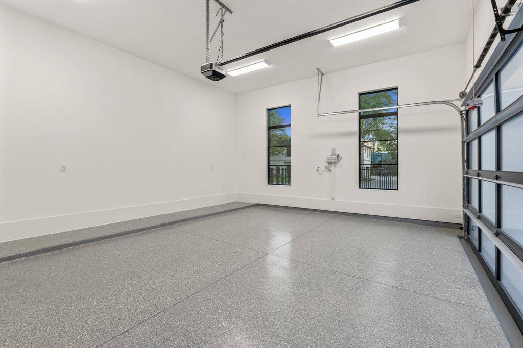 Both garages feature glass-and-aluminum doors with openers, epoxy flooring and LED lighting.