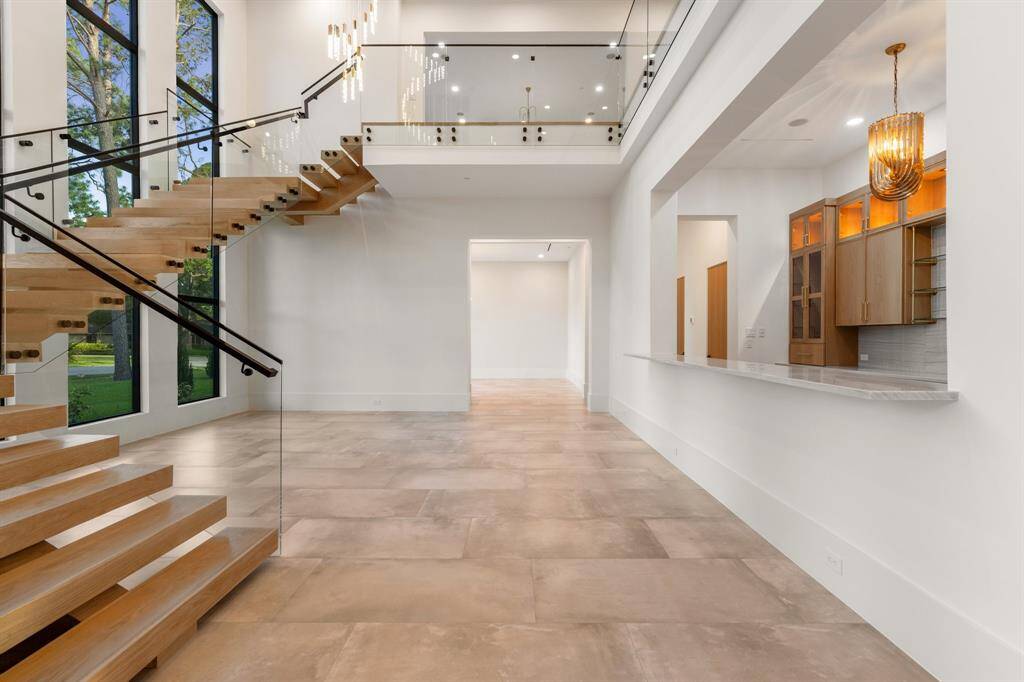 Enjoy a wonderful flow for lavish, large-scale entertaining with the glamorous entryway leading to the stunning formal living room flanked by a walk-up wet bar.