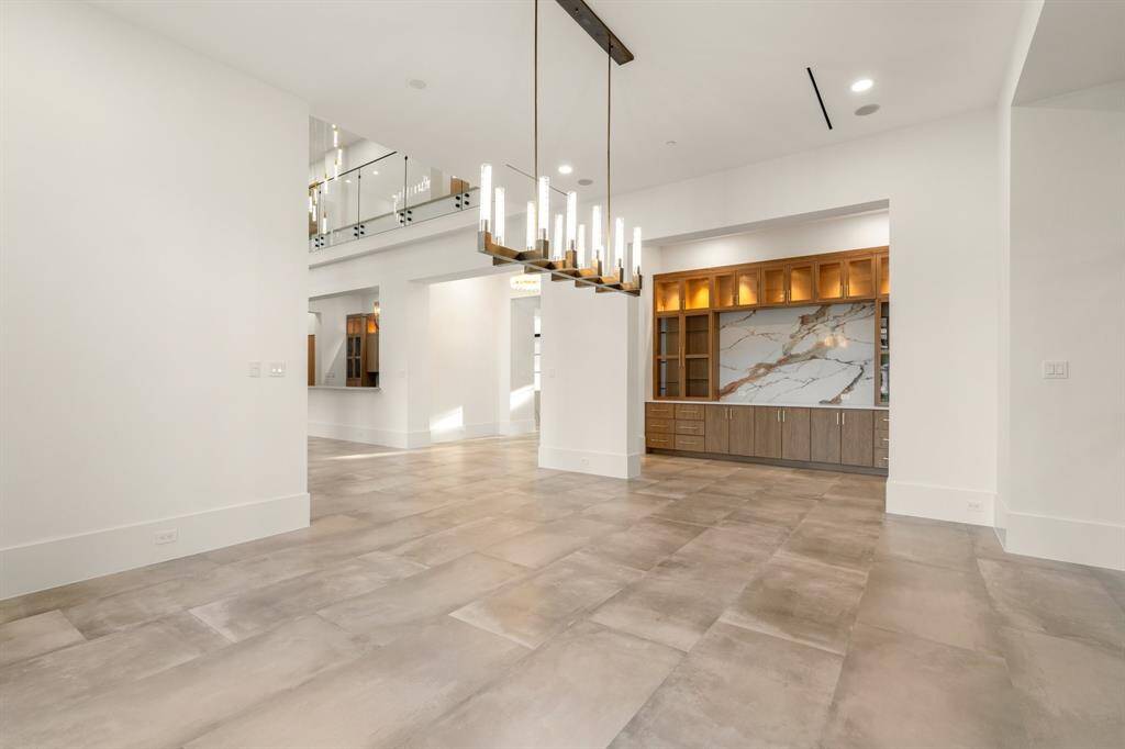 The formal dining room boasts an ideal location surrounded by the entry, formal living room, walk-up bar, wine room, butler’s pantry and powder room.