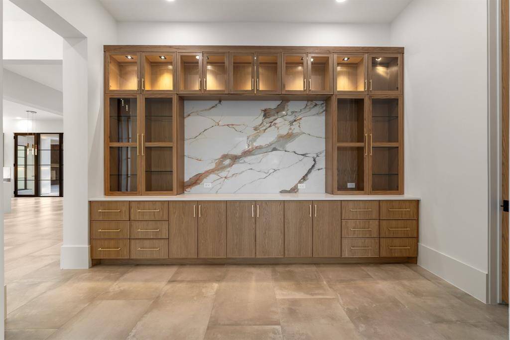 Alongside the dining room, the butler’s pantry provides excellent storage and buffet counter space alongside a handsome stone feature wall. To the right, you’ll find the convenient powder room.