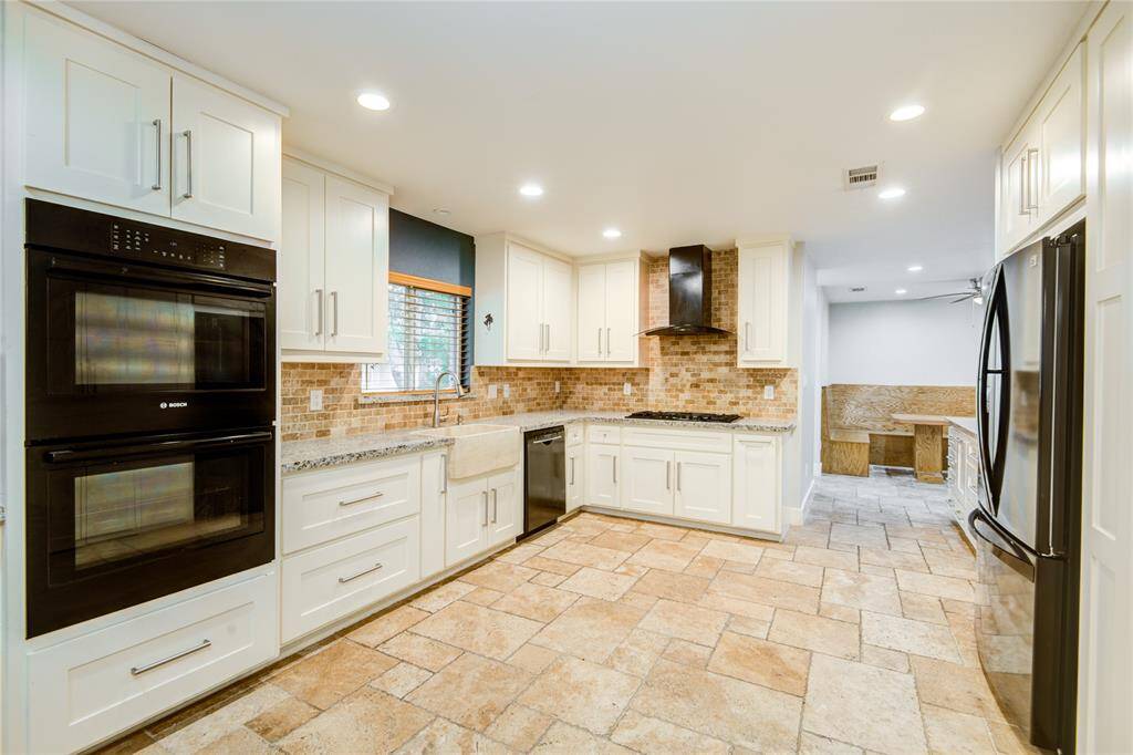 Double oven, two fridges, & sink in kitchen & adjoining laundry