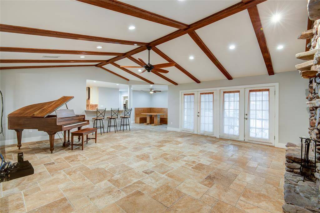 Wall of French doors lead to the sun room & pool
