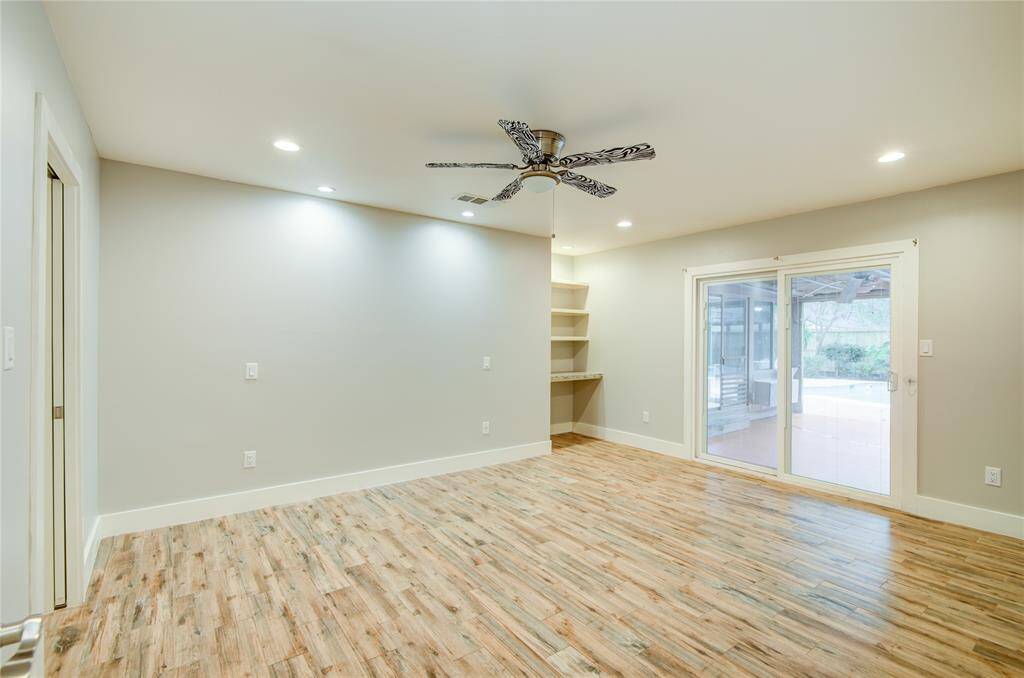 3rd bedroom w/ built in desk & doors have inset mini blinds leading to pool