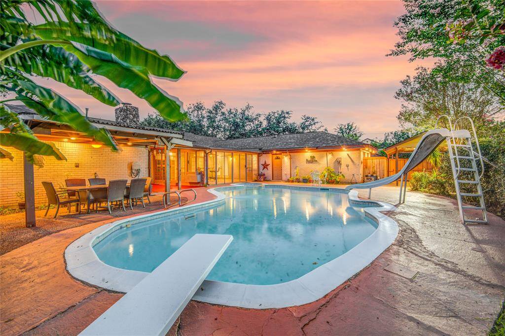 Diving board over 12ft deep end & slide w/ water across from covered seating