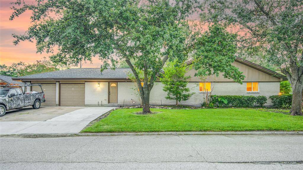 Oak trees surround brick home & widened driveway accommodates 5 cars easily