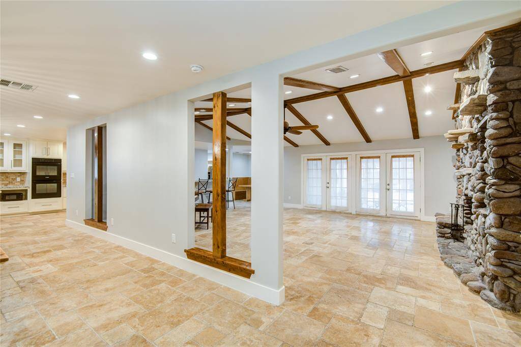 View from entry w/ unique detailing including wood beams.& cut outs in dividing wall for open concept feel