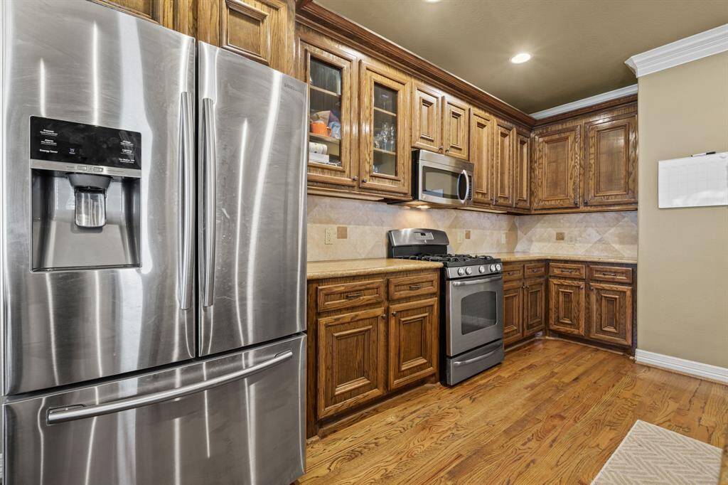 Host your next dinner party with confidence! This masterfully-equipped kitchen features stainless-steel appliances, under cabinet lighting, crown molding details, and recessed lighting.