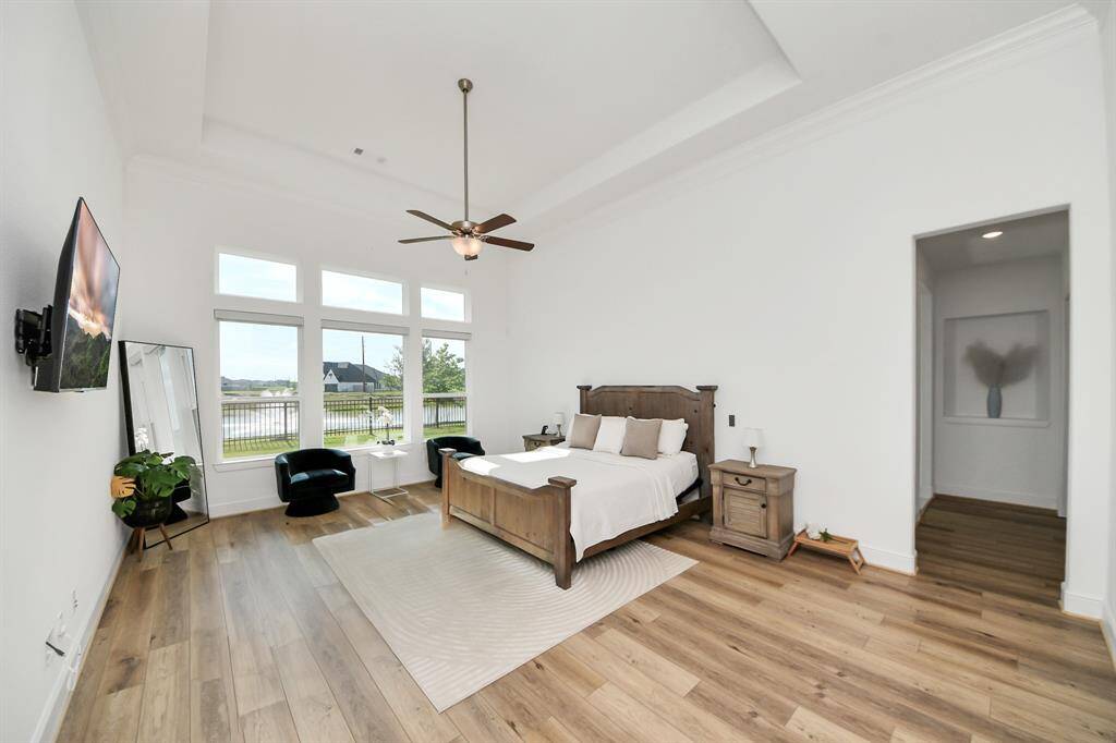 Nestled in its own private corner, the Primary Suite featuring tray ceilings and a seating area that overlooks the water.