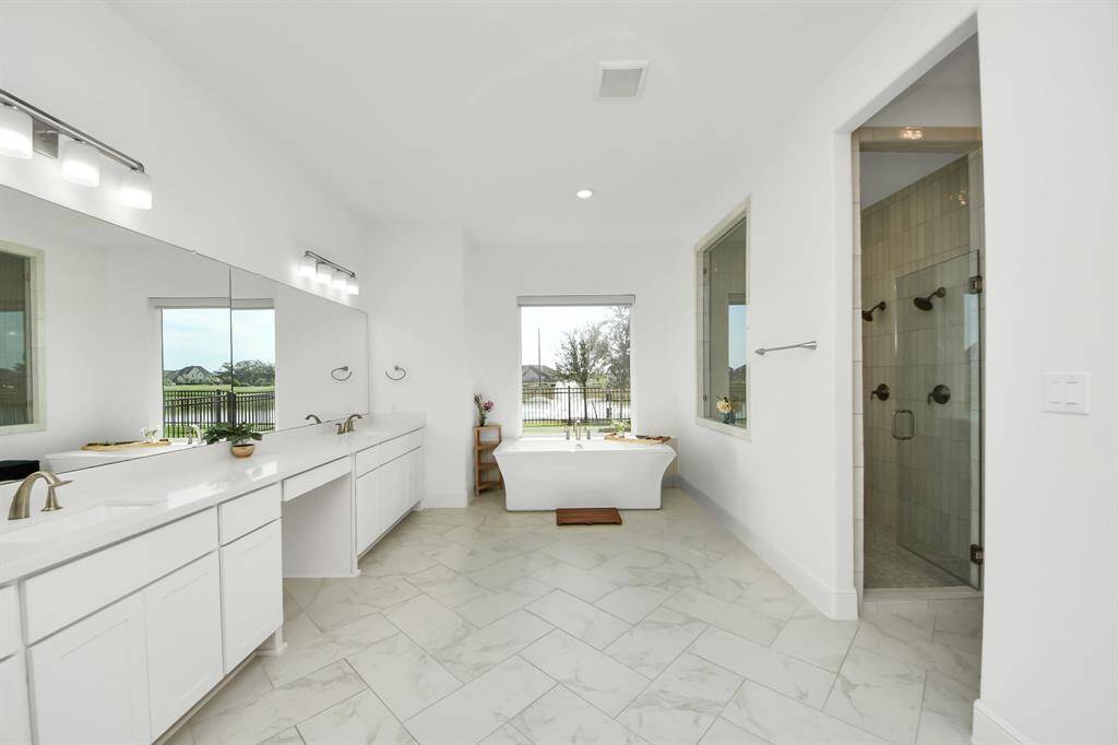 This spa-like bathroom with a stand-alone tub, oversized shower, and a spacious walk-in closet is a luxurious sanctuary.