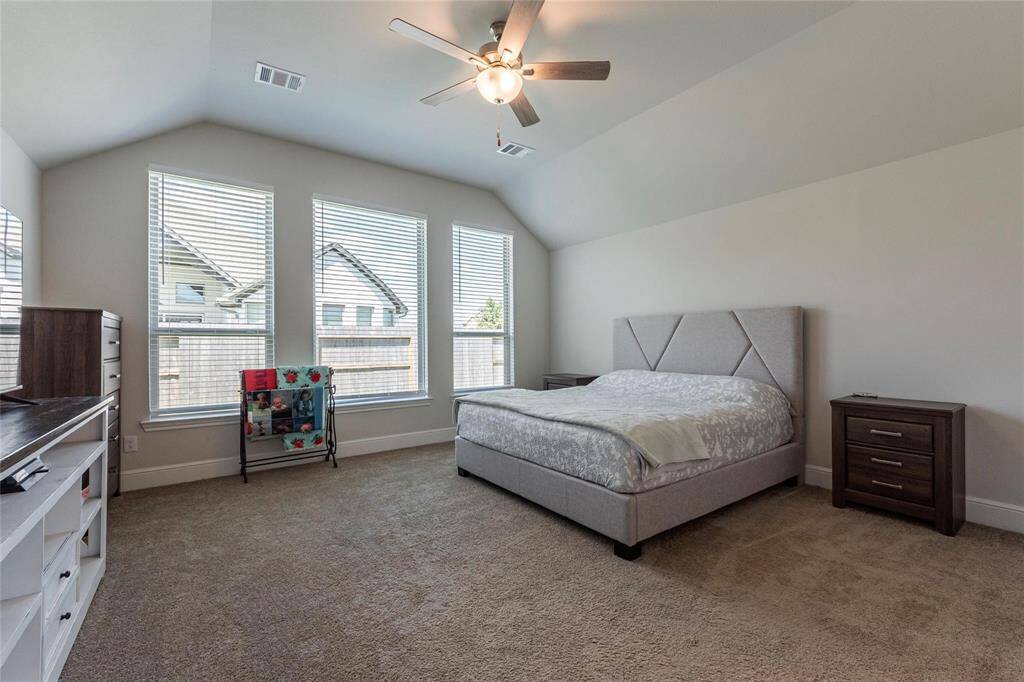 Huge primary bedroom with high ceilings, 2" blinds and neutral paint tones.