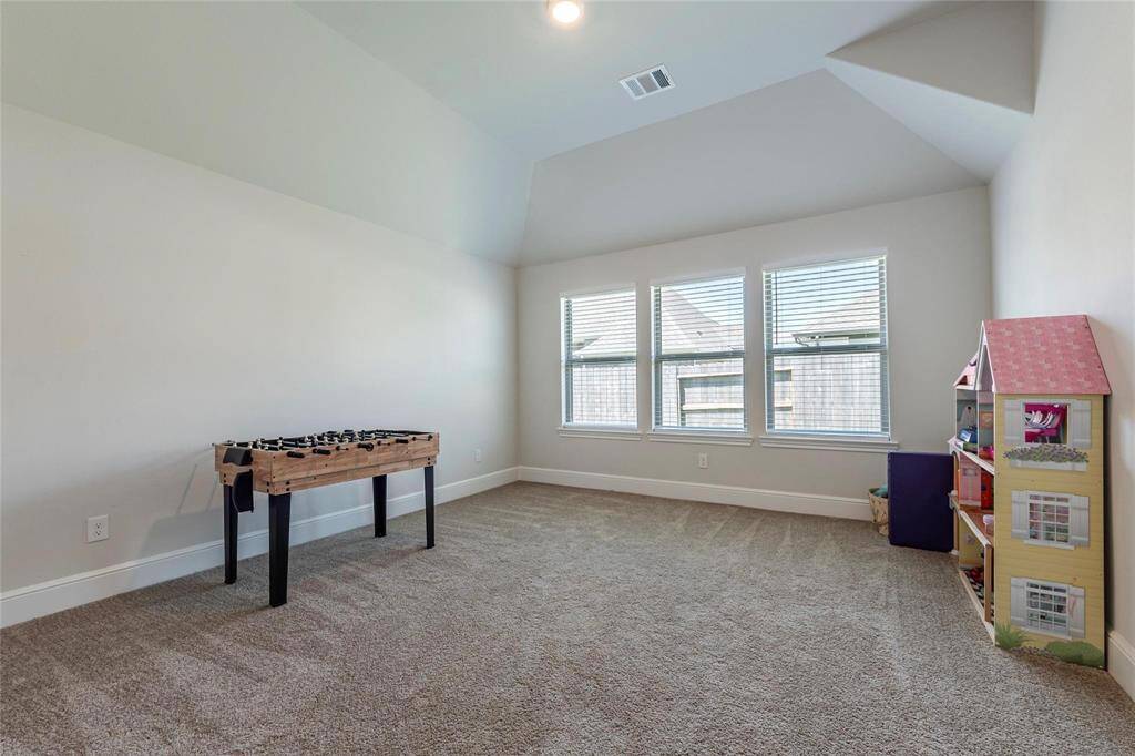 Spacious game room at the back of the home with backyard views and great natural lighting.