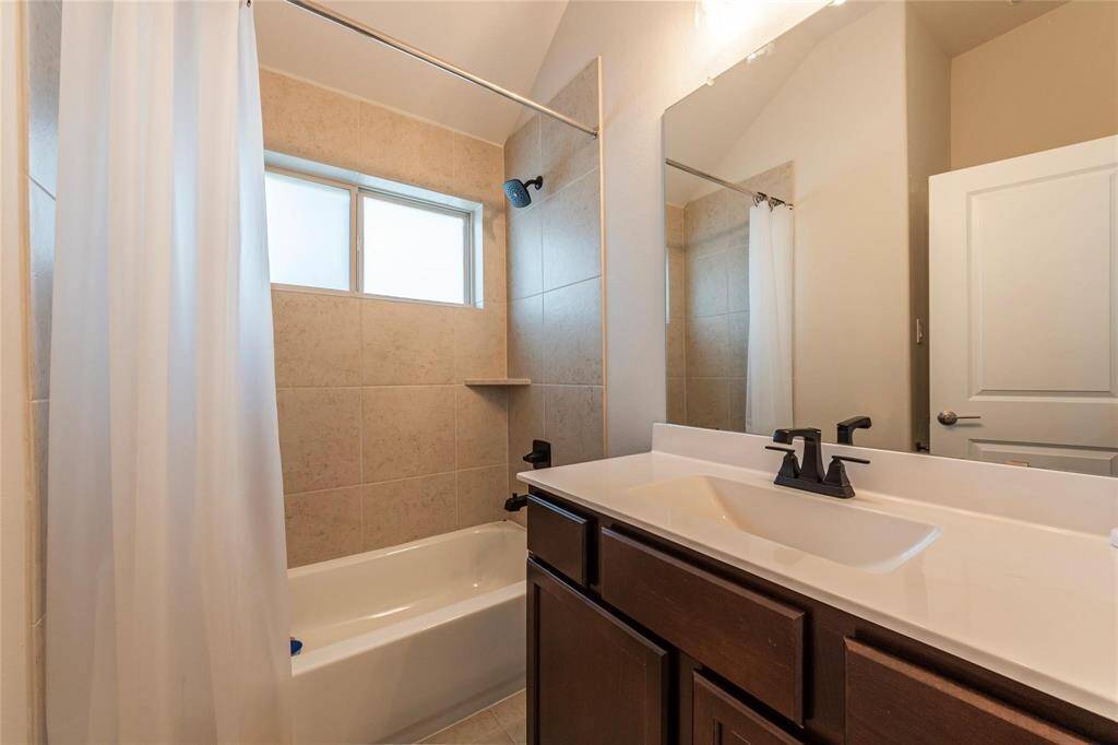 3rd full bath with large vanity, tile flooring and shower/tub combination.