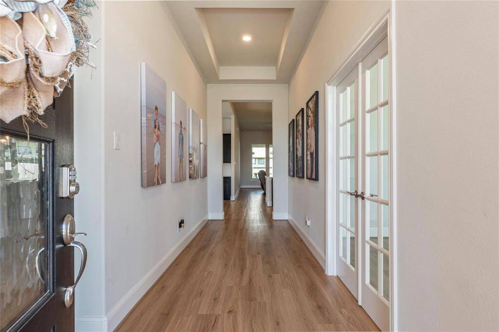 Inviting entryway with vinyl plank flooring and high ceilings.