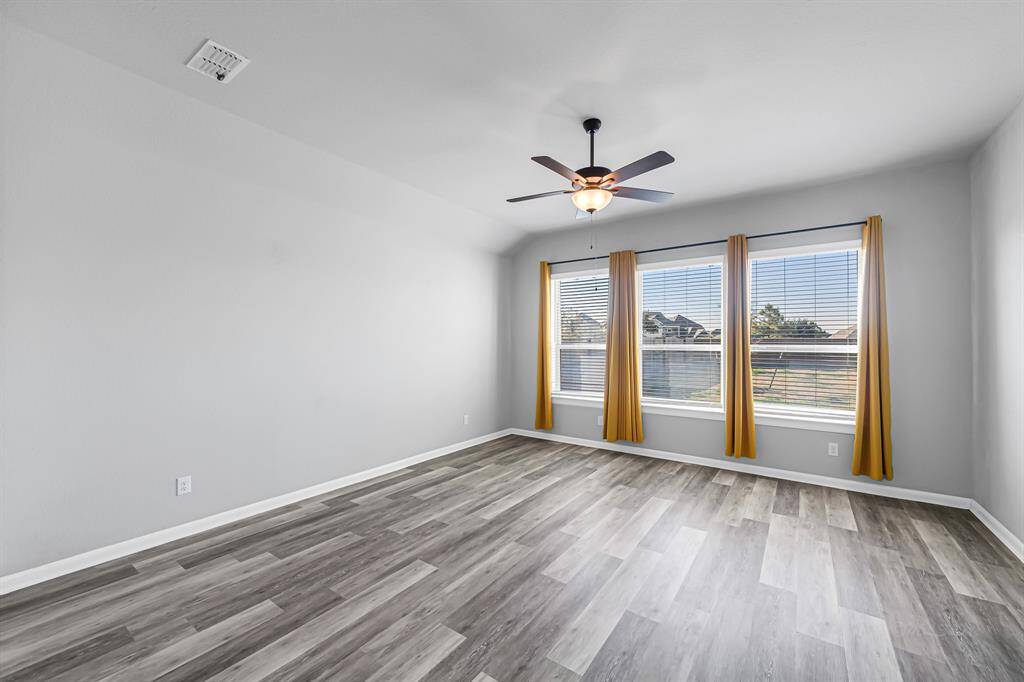 The primary bedroom is tucked away at the back of the home with large windows and a view of the backyard.