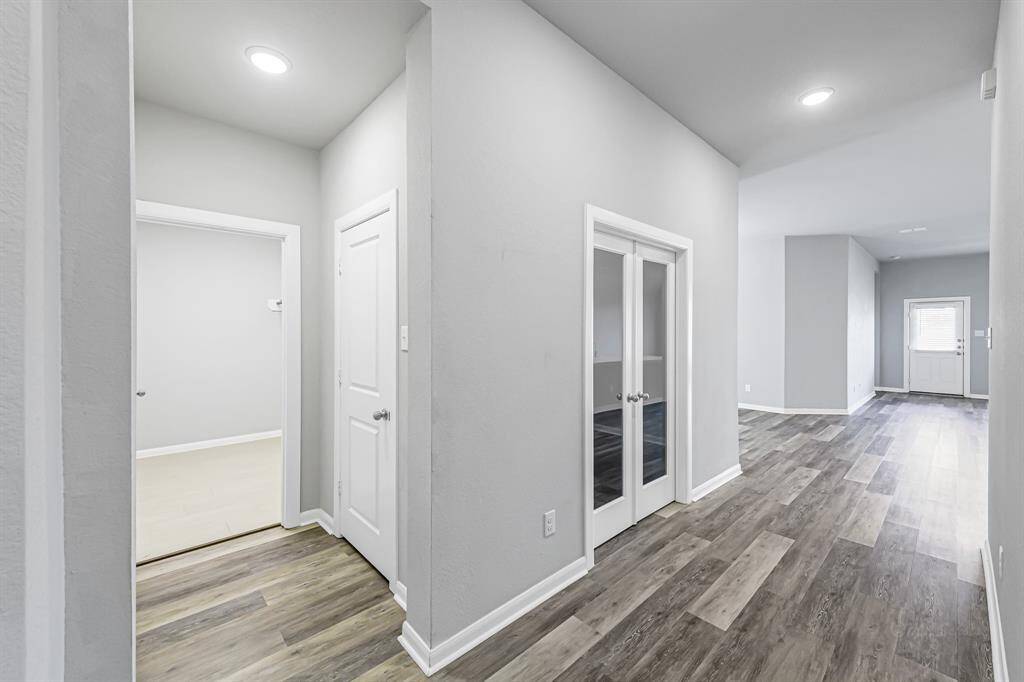 Entry hallway with access to the great sized laundry room, a closet for storage and french doors to the home office.