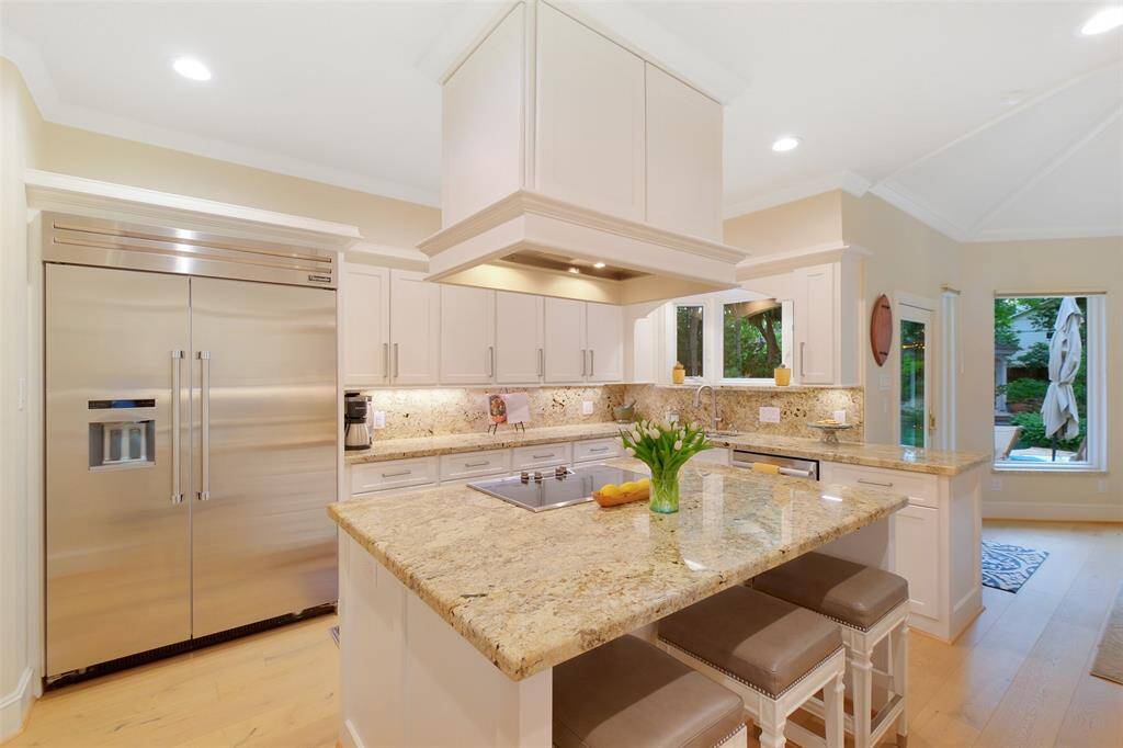 The Island Kitchen features Thermador appliances, custom cabinets, gorgeous granite countertops, island seating, and under-mount cabinet lighting.