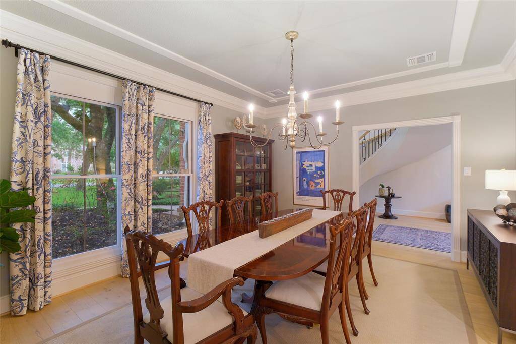 The welcoming and spacious Formal Dining Room with designer custom draperies, double crown molding and Chandelier are an entertainer's delight!