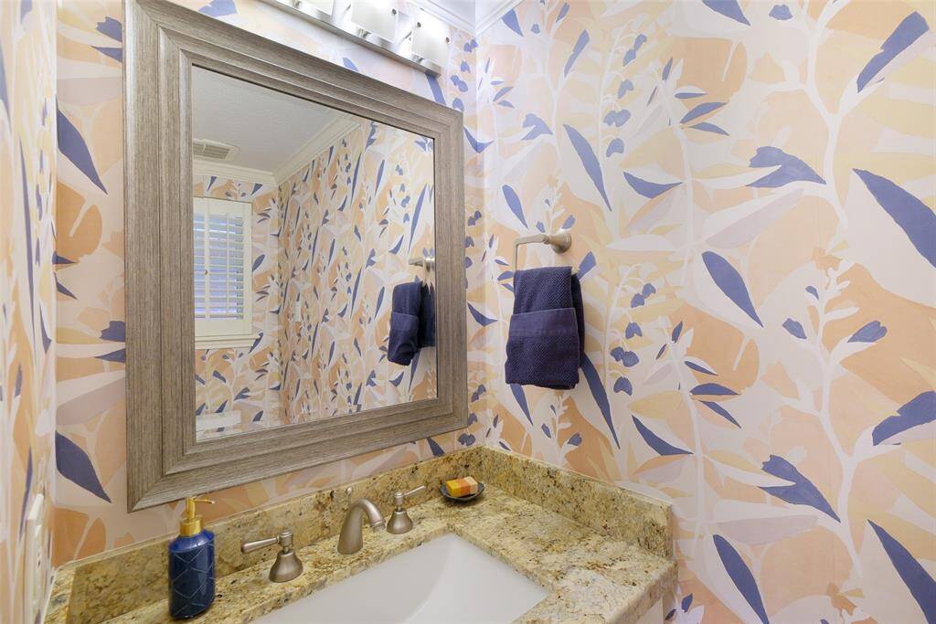 A Powder Bath with granite countertops servicing the Dining/Kitchen area of the home. Please note, this is the easy removable wallpaper.