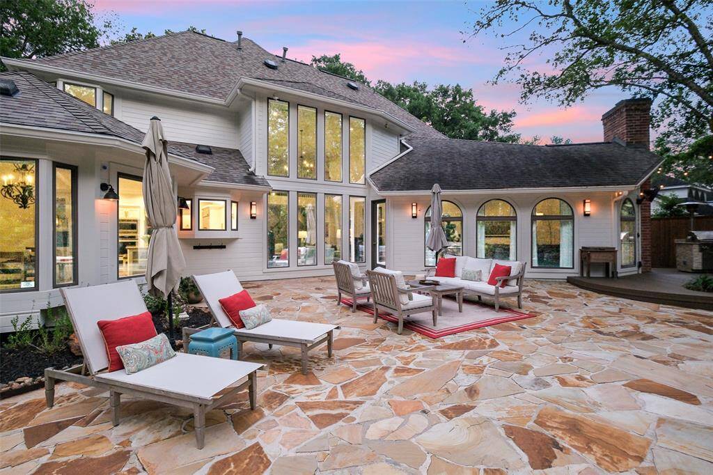 Looking back at the home over the impressive Patio, a great place to sun or just savor the splendor of the beauty of this oasis around you! The "Walls of Windows" evident across the back of the home ensure that being inside doesn't mean one would miss the absolute beauty of this backyard!