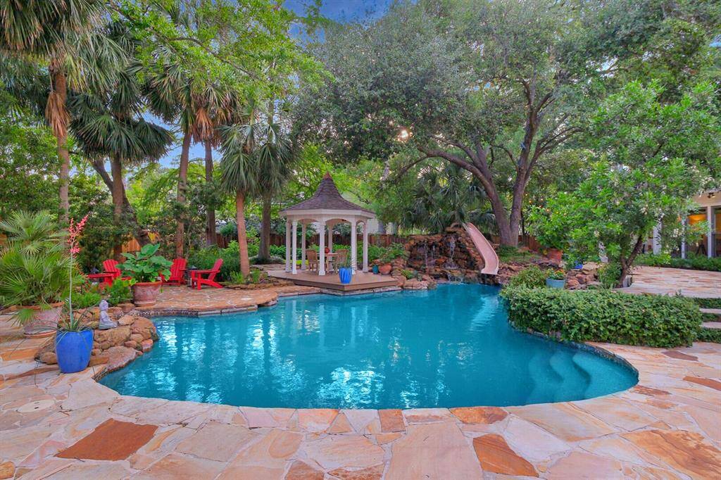 This Pool picture makes a statement your family and friends will never forget! A Gazebo, Rock Wall Waterfall with a Slide, and Flagstone decking are not only professionally planned but this Pool is just plain FUN and includes recently installed LED coloring changing pool lights.