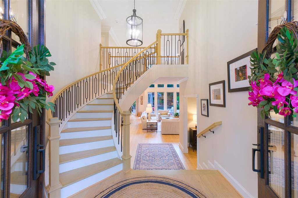 This Double-Door front entry scene is breathtaking with the updated Iron Balusters and Hardwoods on the gently curving Spiral Staircase, double coat closets and a hint of unforgettable pool views.