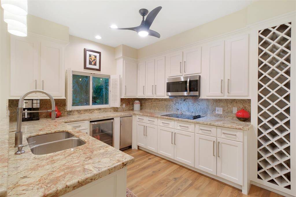 Full Kitchen with pass through window to Pool Area, Beverage Frig, Microwave, Cooktop, Dishwasher and built-in Wine Shelving, Granite Countertops and Custom Cabinets, Breakfast Bar. A lot to love in this 1,198 sf Guest House!