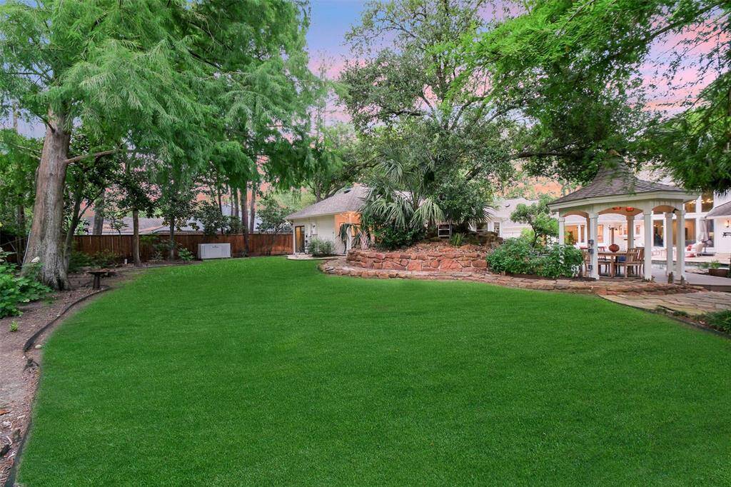 The sprawling backyard behind the pool and gazebo area is perfect for play and pets. Lush, professionally landscaped trees, native Texas plants and shrubs create a wonderful accent to the gem-like beauty of the Pool. Notice the generator that services the whole house, guest house and pool!