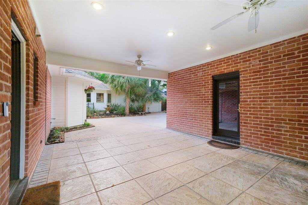 Inviting Porte-Cochere for additional covered parking just beyond driveway gate.