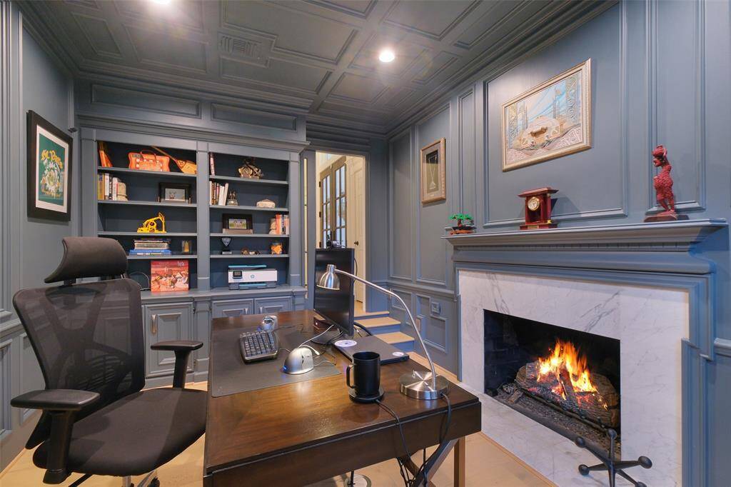 A reverse view of the Office/Study with it's built-in shelves, recessed lighting and a gas log fireplace.  For added privacy, a glass pocket door can be employed.