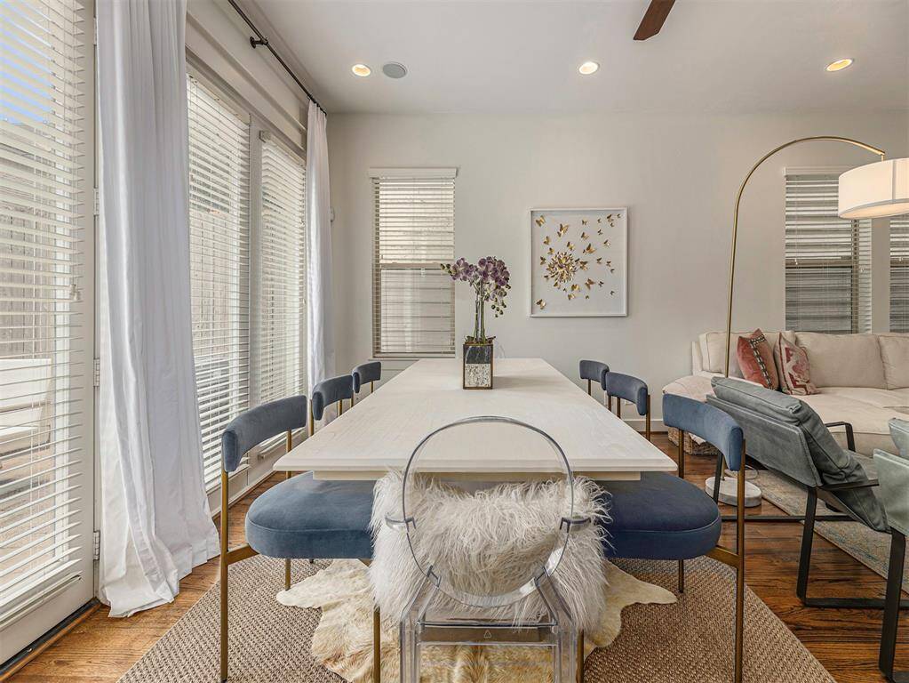Bright dining area with large windows, modern furniture, and elegant decor, seamlessly connected to a cozy living space.