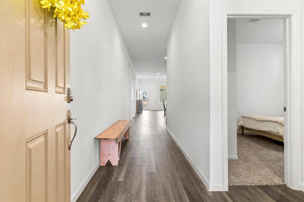 As you enter, a welcoming hallway leads you to two well-appointed secondary bedrooms, offering both privacy and convenience right off the main entryway.