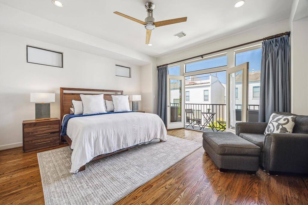 Located on the 3rd floor alongside secondary bedroom #1, the spacious primary suite offers plenty of room for an office or sitting area. Features include a ceiling fan/light fixture, recessed can lighting, hardwood floors, and large windows with pull-down blackout shades and drapes. French doors open to a private balcony with a peaceful view of the backyard.